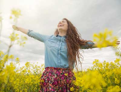 Woman in field of flowers smiling optimized
