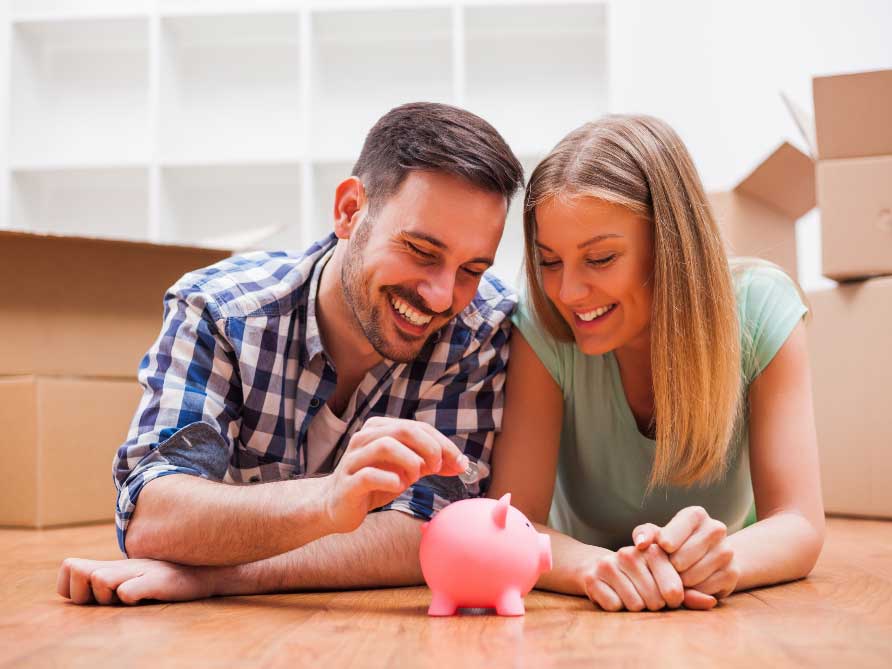 happy couple saving money piggy bank