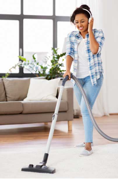 woman listening to music cleaning rug